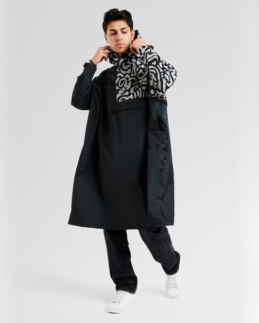 Poncho de pluie noir design pour vélo, avec détails réfléchissants intégrés et coupe ample adaptée à la mobilité urbaine.